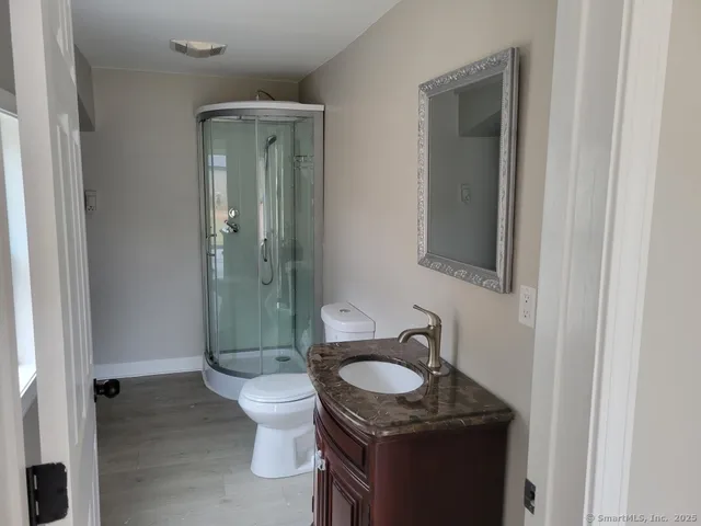 a bathroom with a granite countertop sink toilet and shower