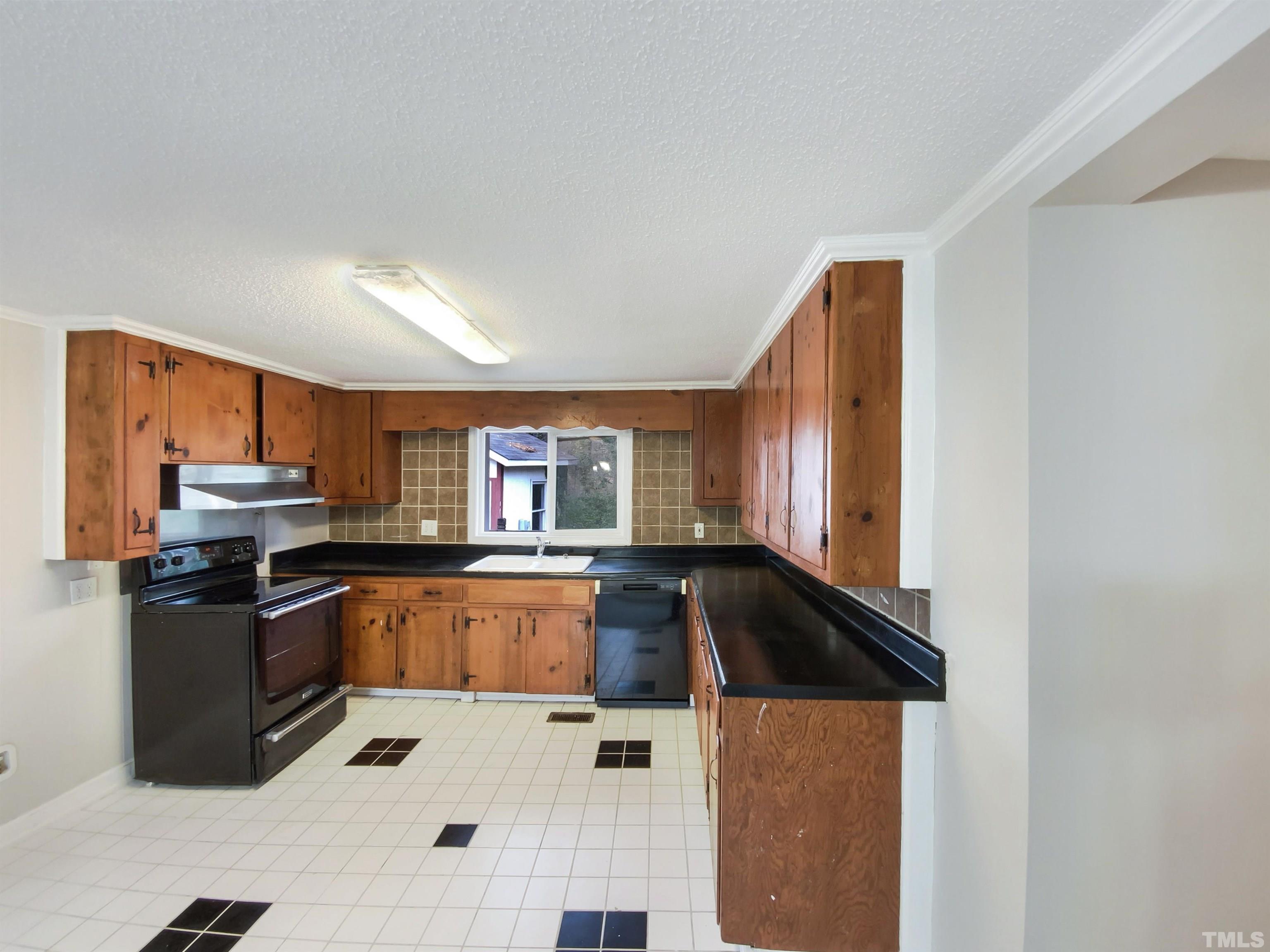 a kitchen with granite countertop a refrigerator stove and sink