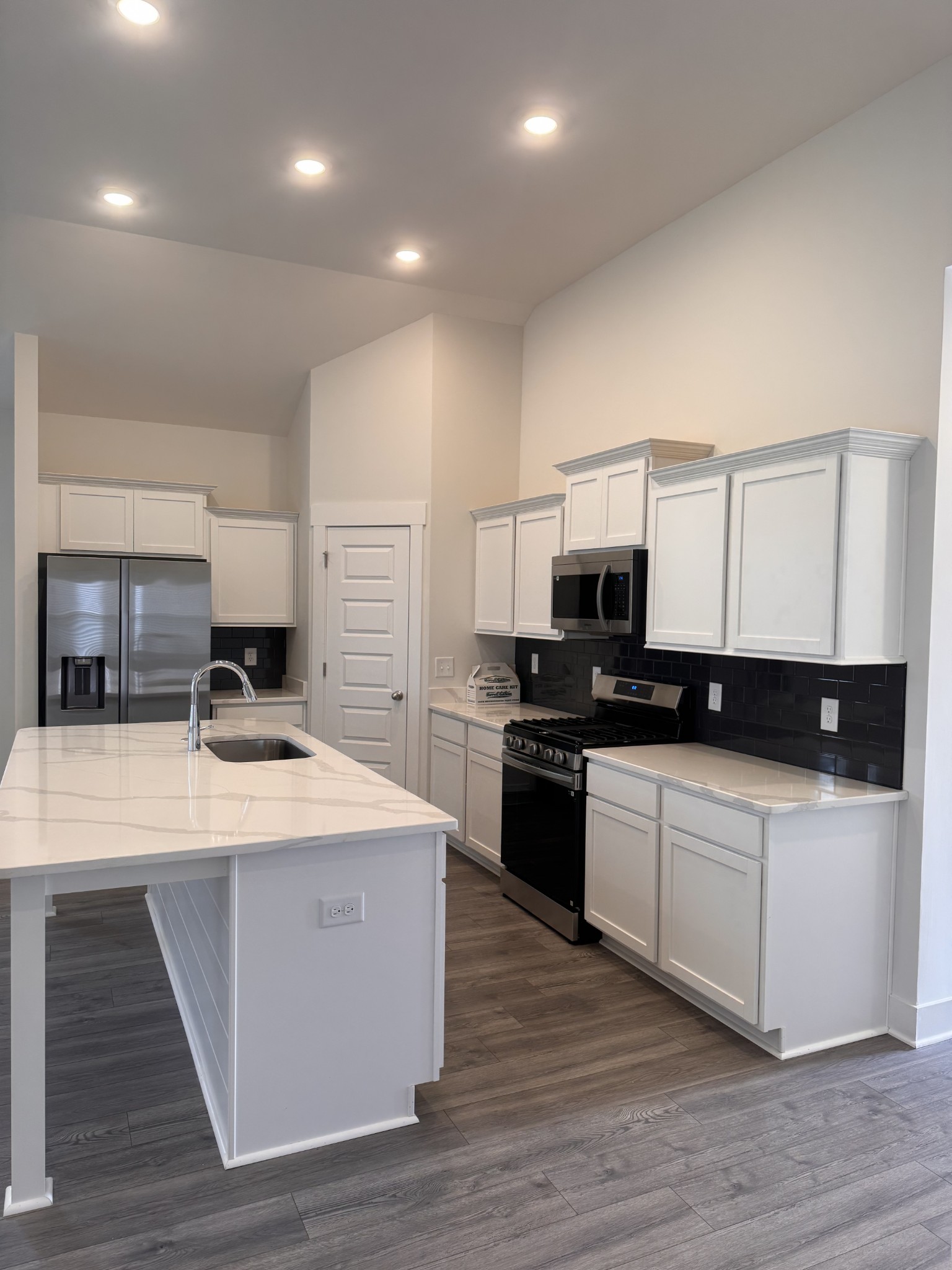 5572 Rooker Road Smyrna, TN 37167 - Photo 3 of 13 a kitchen with stainless steel appliances kitchen island granite countertop a stove top oven a sink a counter top space and cabinets