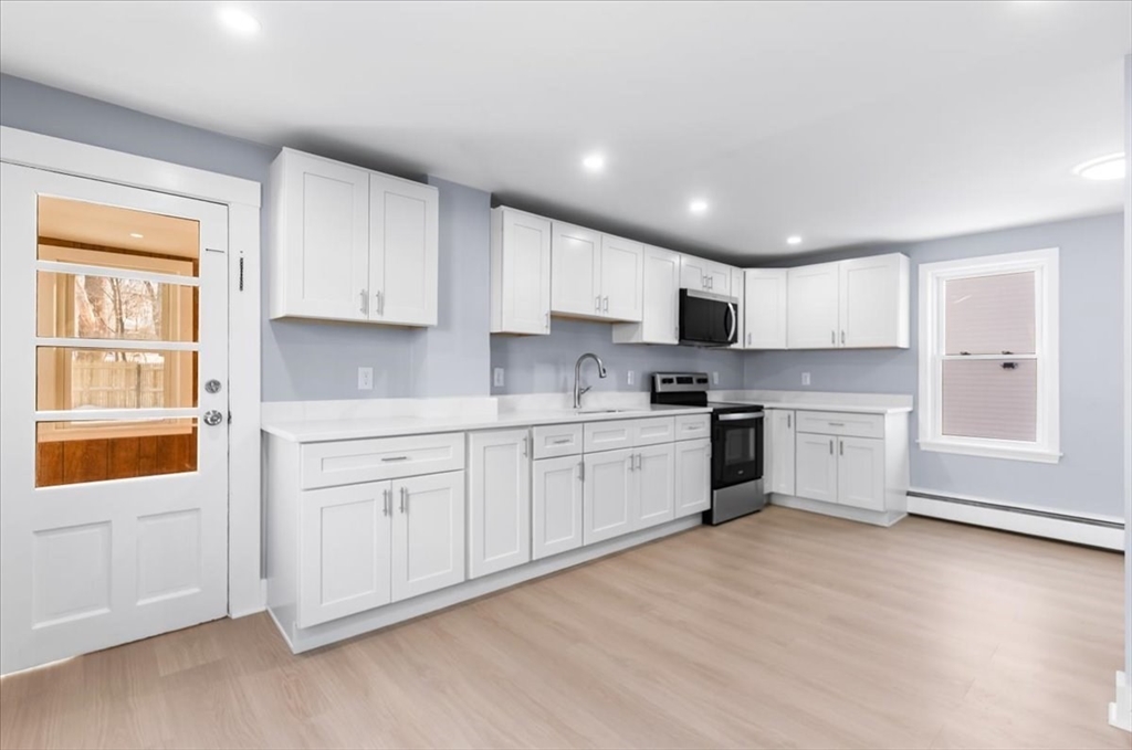 31 Webster Street Winchendon, MA 01475 - Photo 12 of 32 a kitchen with granite countertop white cabinets and white appliances