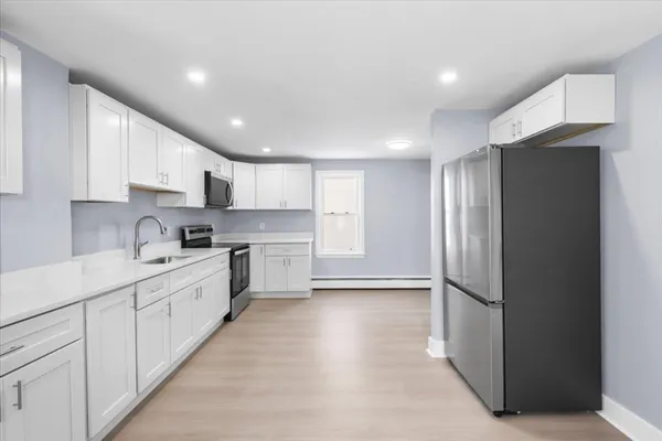 a kitchen with white cabinets and white appliances