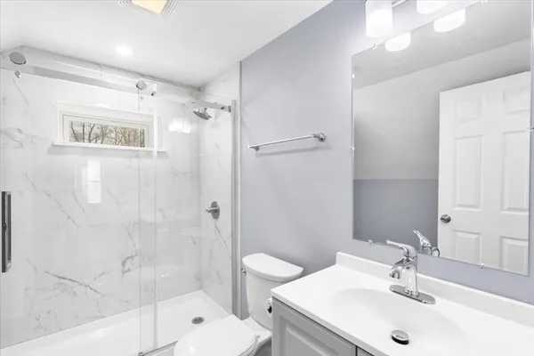 a bathroom with a sink a toilet and shower