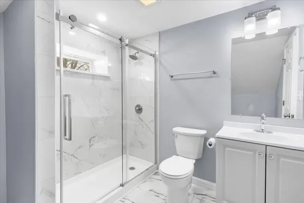 a bathroom with a granite countertop sink toilet and shower