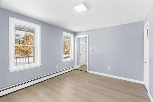 an empty room with wooden floor and windows