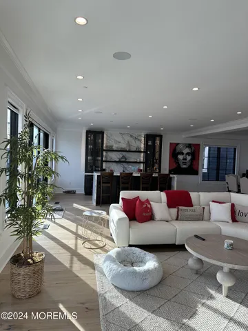 a living room with furniture a rug and kitchen view
