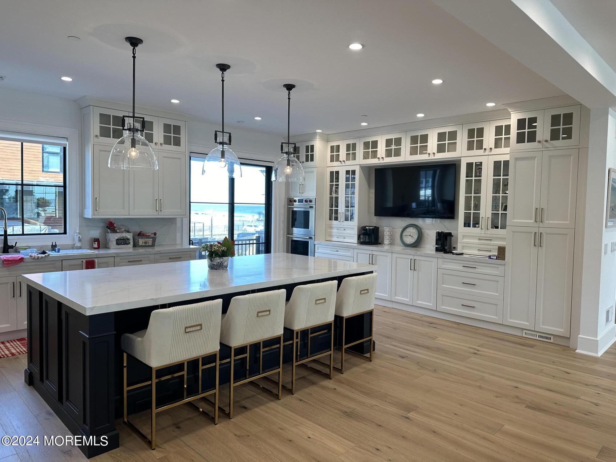 13 Ocean Terrace Long Branch, NJ 07740 - Photo 15 of 49 a large kitchen with stainless steel appliances kitchen island granite countertop a table chairs sink and wooden floor