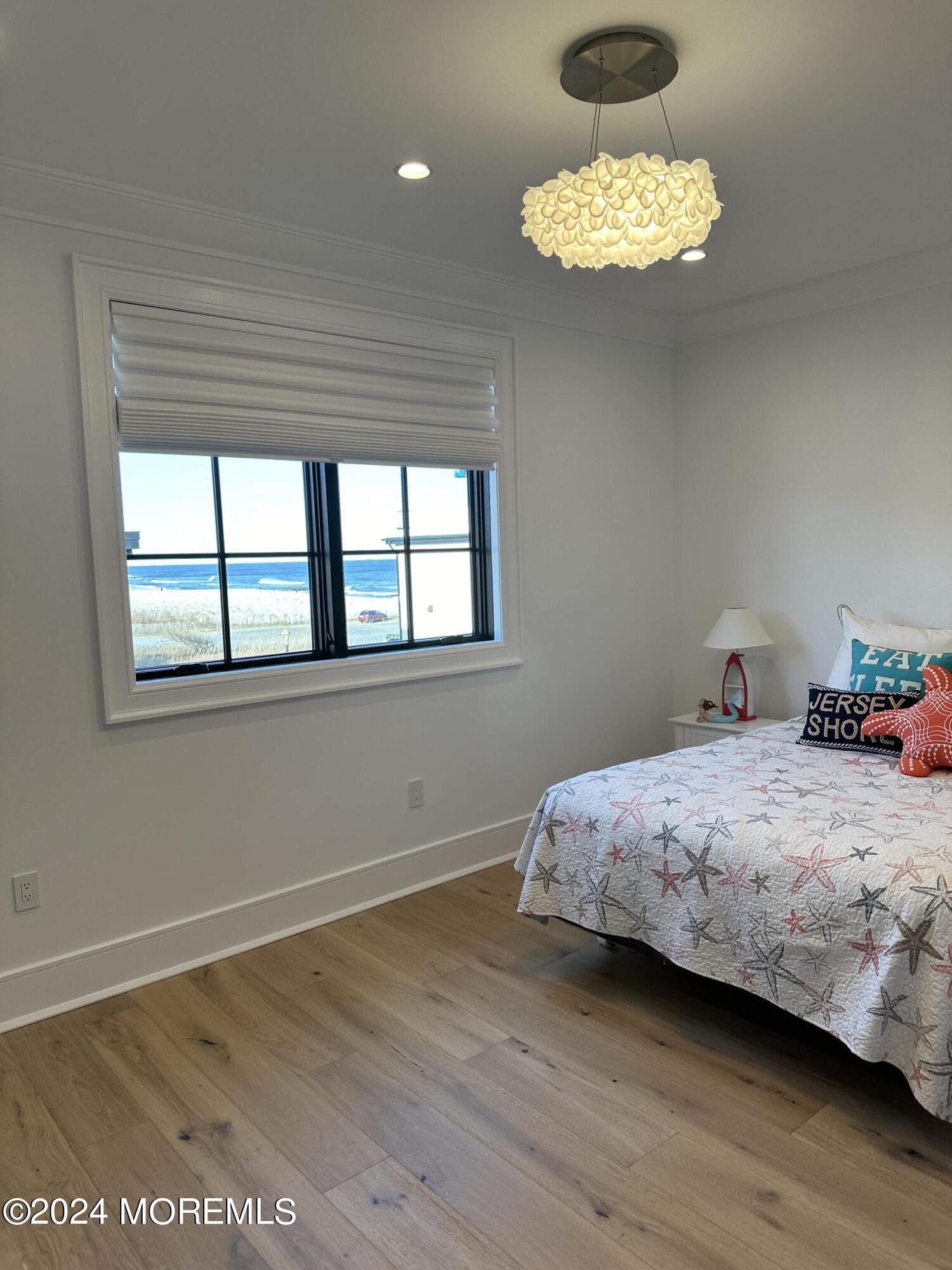 13 Ocean Terrace Long Branch, NJ 07740 - Photo 33 of 49 a bedroom with a bed and a chandelier