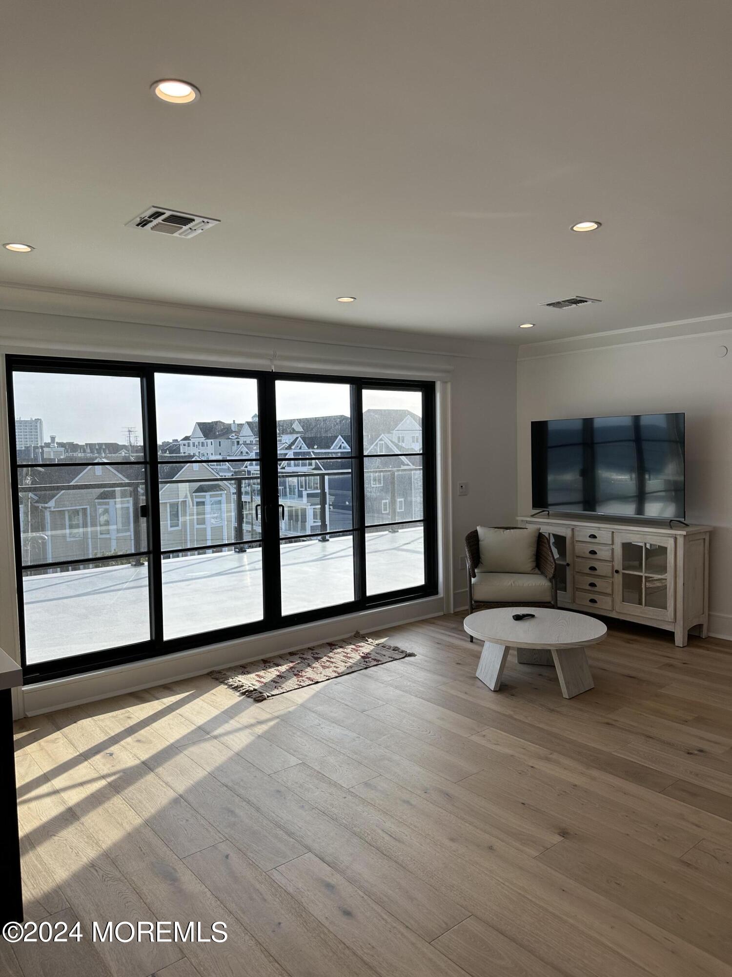 13 Ocean Terrace Long Branch, NJ 07740 - Photo 39 of 49 a living room with furniture large windows and flat screen tv