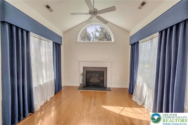 a view of an empty room with a fireplace and a window