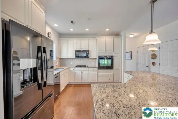 a large kitchen with stainless steel appliances kitchen island granite countertop a large counter top and stove top oven