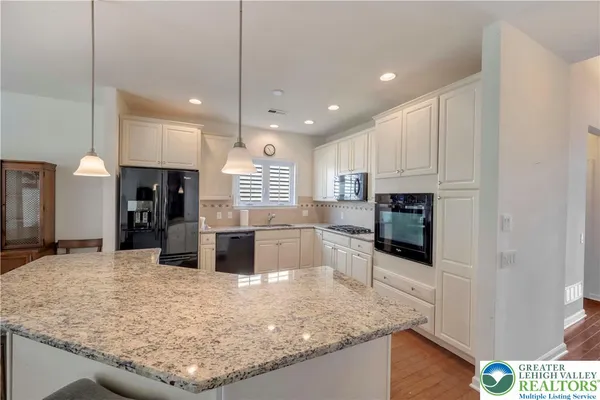 a kitchen with stainless steel appliances granite countertop a sink a stove and a wooden floors