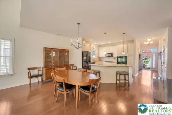 a dining area with stainless steel appliances kitchen island granite countertop a table and chairs