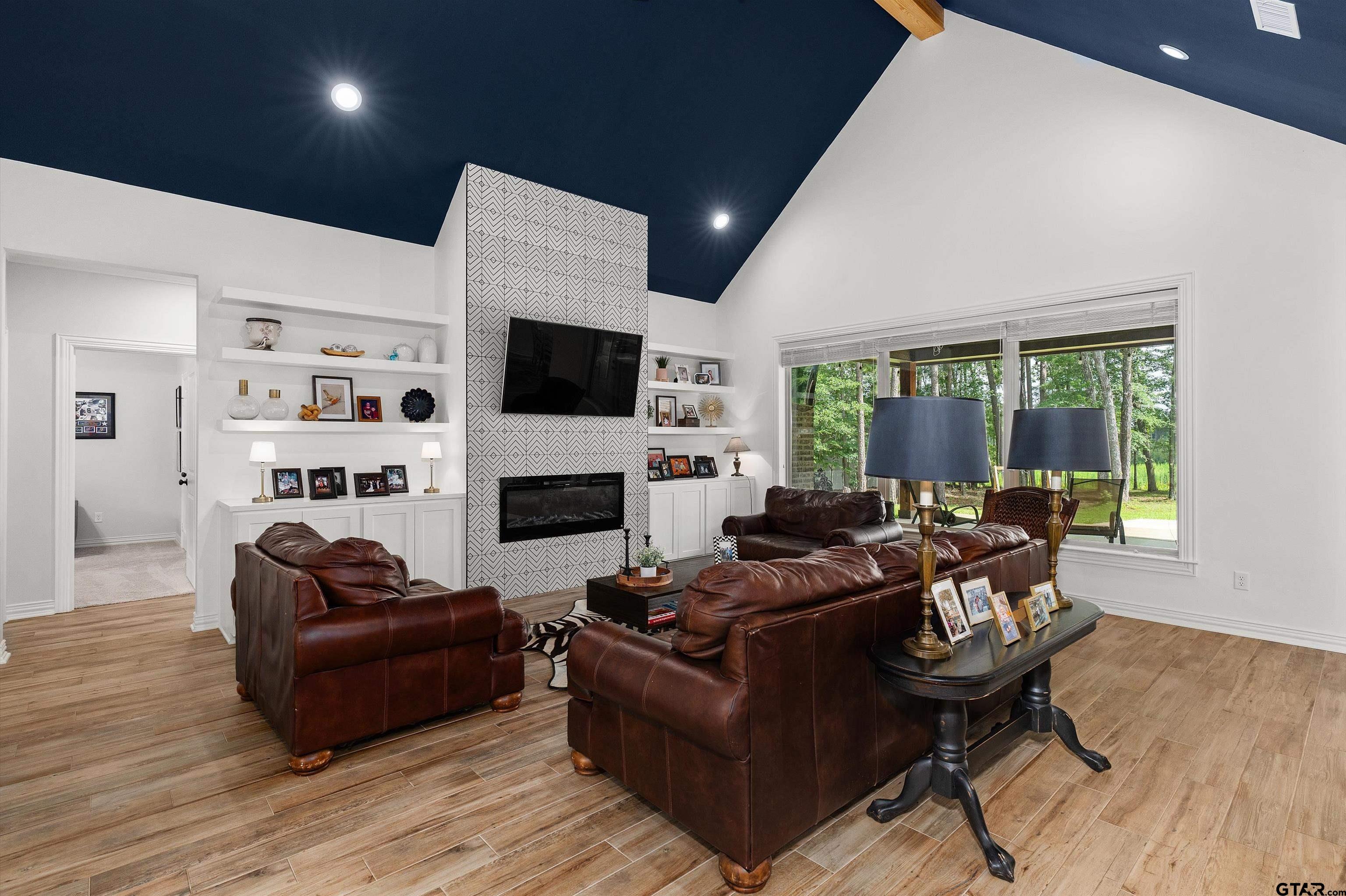 434 King Ranch Road Kilgore, TX 75662 - Photo 16 of 34 a living room with furniture a fireplace and a flat screen tv