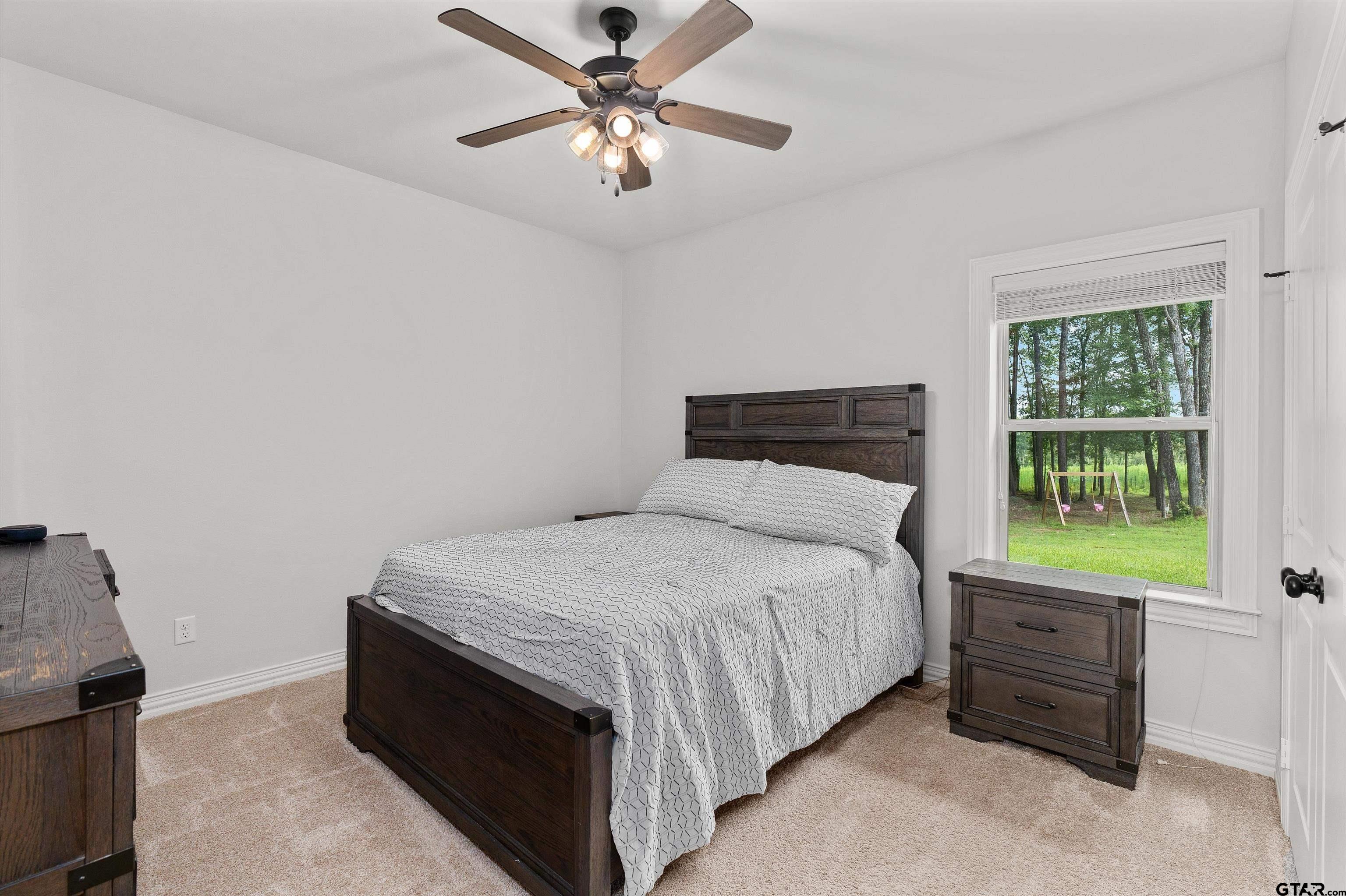 434 King Ranch Road Kilgore, TX 75662 - Photo 29 of 34 a bedroom with a bed and a chandelier