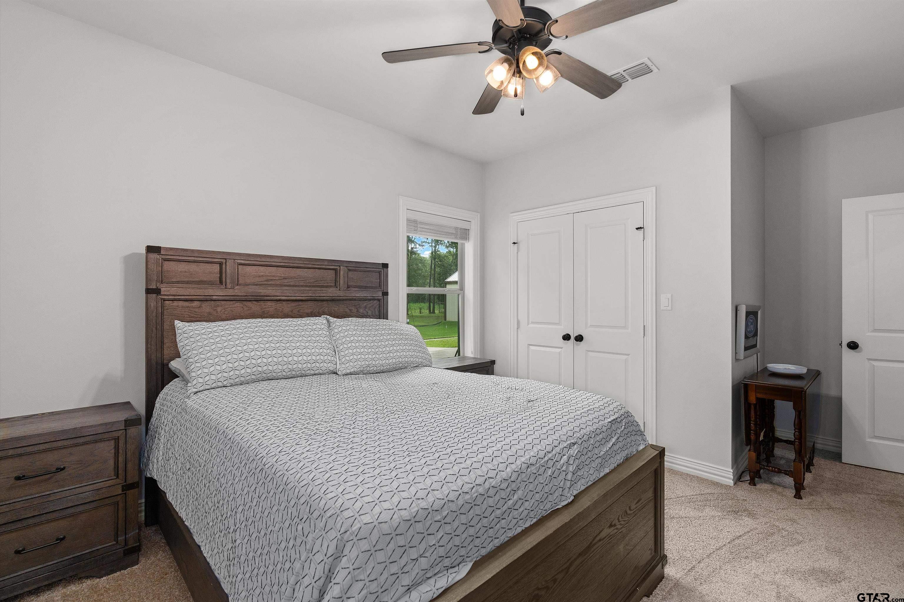 434 King Ranch Road Kilgore, TX 75662 - Photo 30 of 34 a bedroom with a large bed and a chandelier