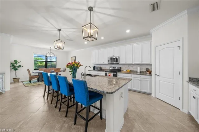a view of kitchen with cabinets dining table and chairs