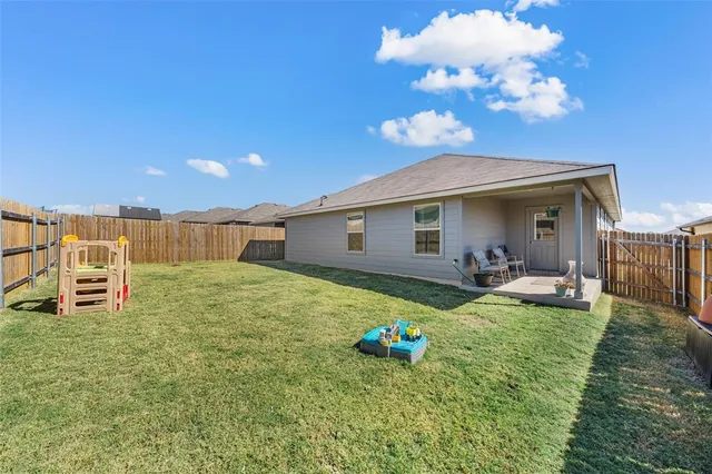 a backyard of a house with table and chairs