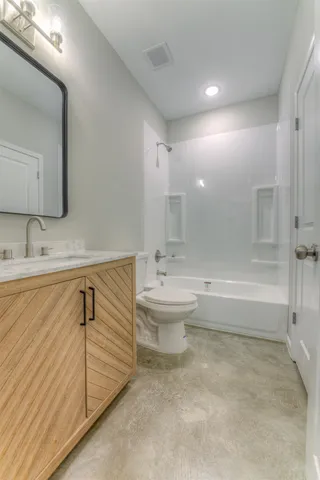 a bathroom with a bathtub shower sink vanity and toilet