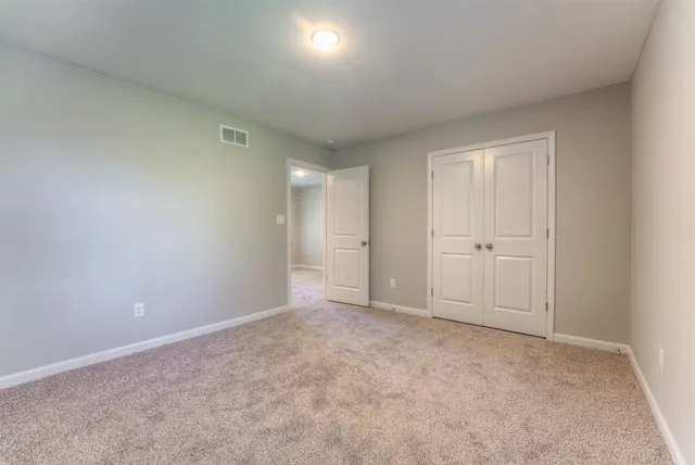 an empty room with windows and closet