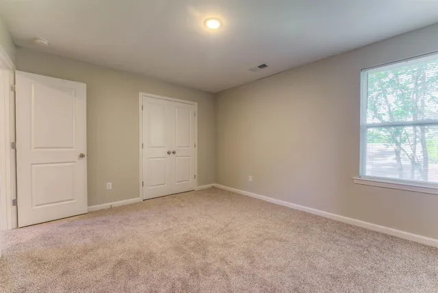 an empty room with windows and closet