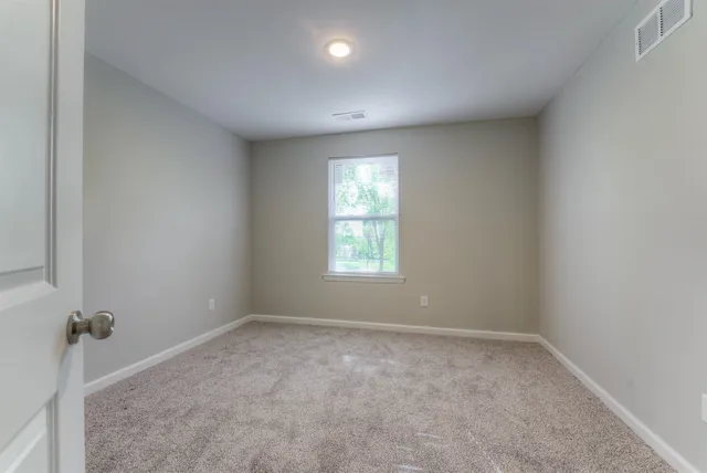 an empty room with a window and a bathroom