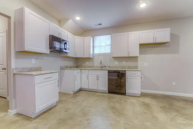 a kitchen with granite countertop white cabinets and white appliances