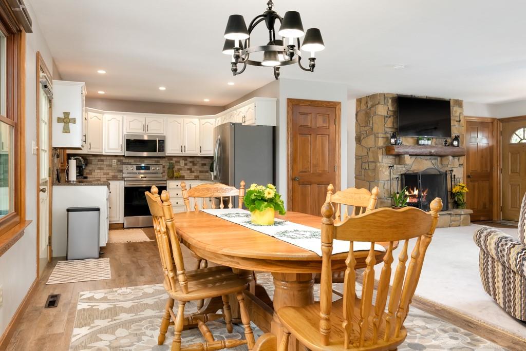 1087 Whitestown Road Butler, PA 16001 - Photo 7 of 25 a view of a dining room with furniture a kitchen a fireplace a rug a chandelier and windows