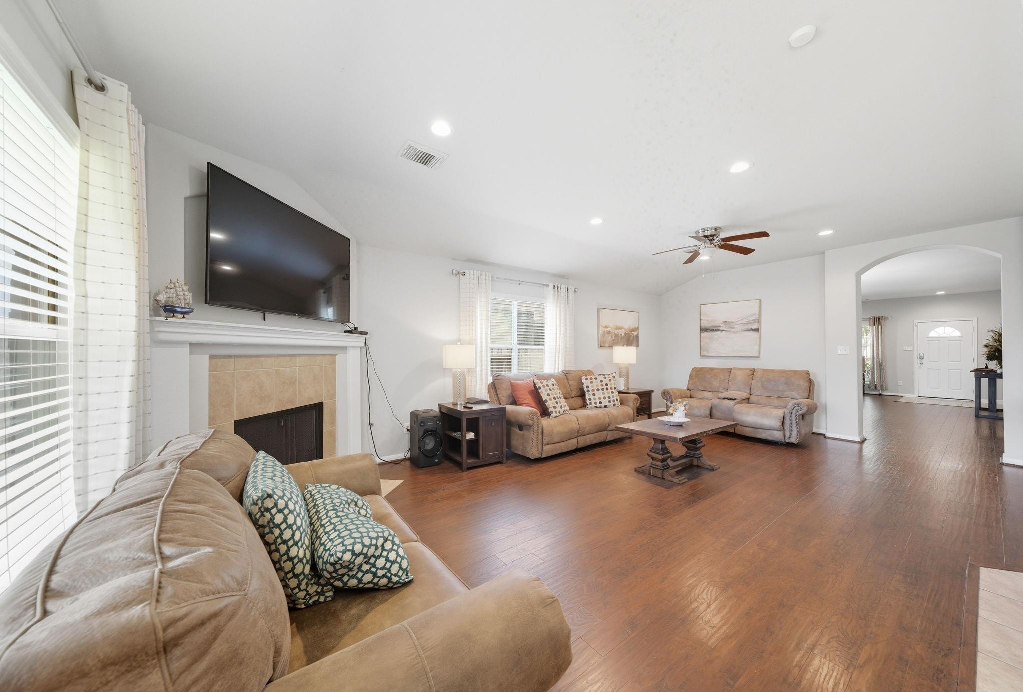 25707 Crisp Spring Lane Spring, TX 77373 - Photo 3 of 14 a living room with furniture a fireplace and a flat screen tv
