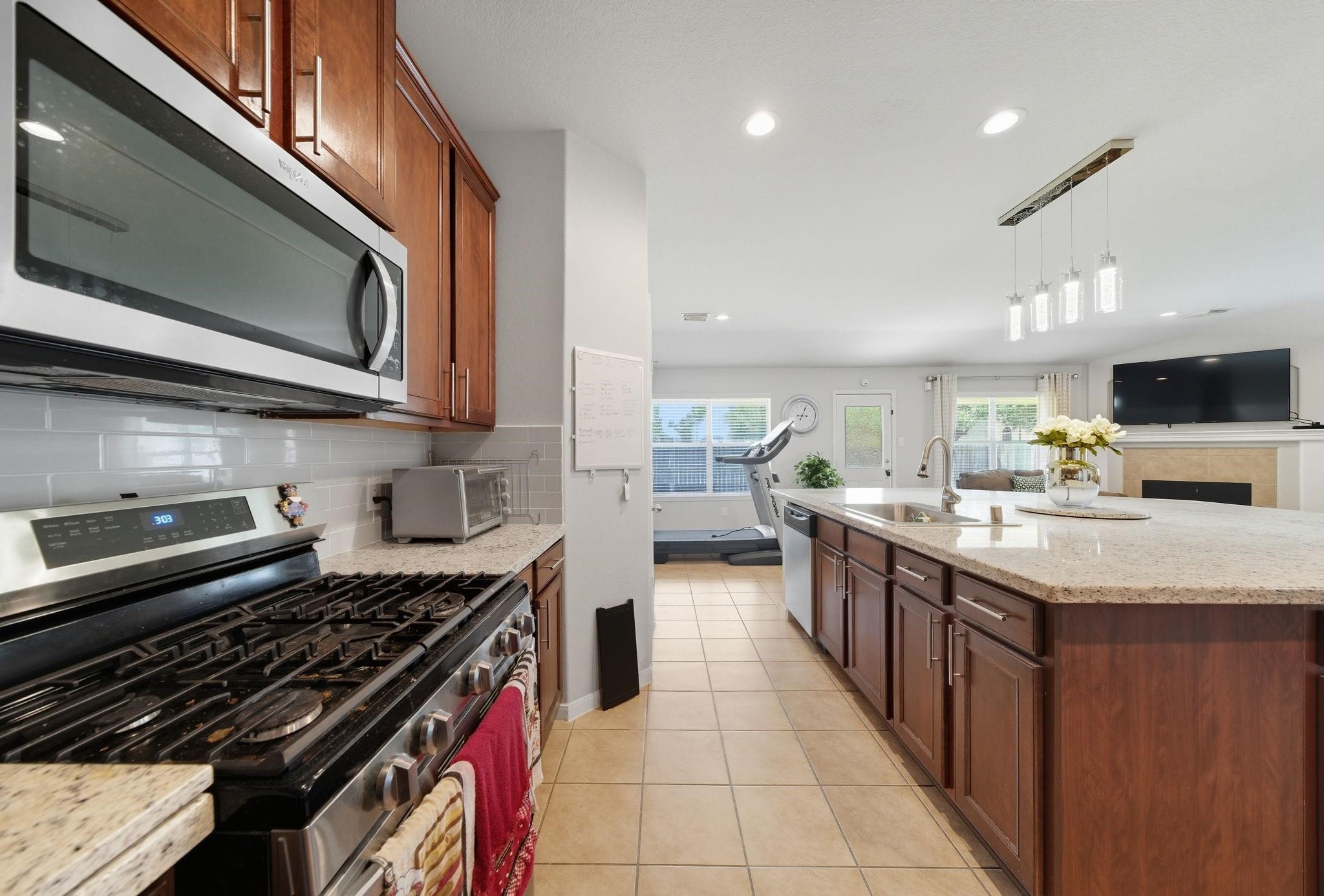 25707 Crisp Spring Lane Spring, TX 77373 - Photo 5 of 14 a kitchen with stainless steel appliances granite countertop a stove and a microwave