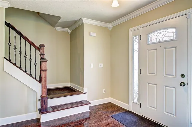 a view of front door with wooden floor and stairs