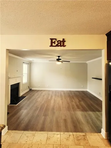 a view of a room with wooden floor and a ceiling fan
