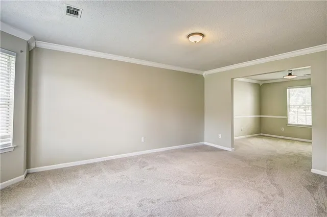 an empty room with a fireplace and windows