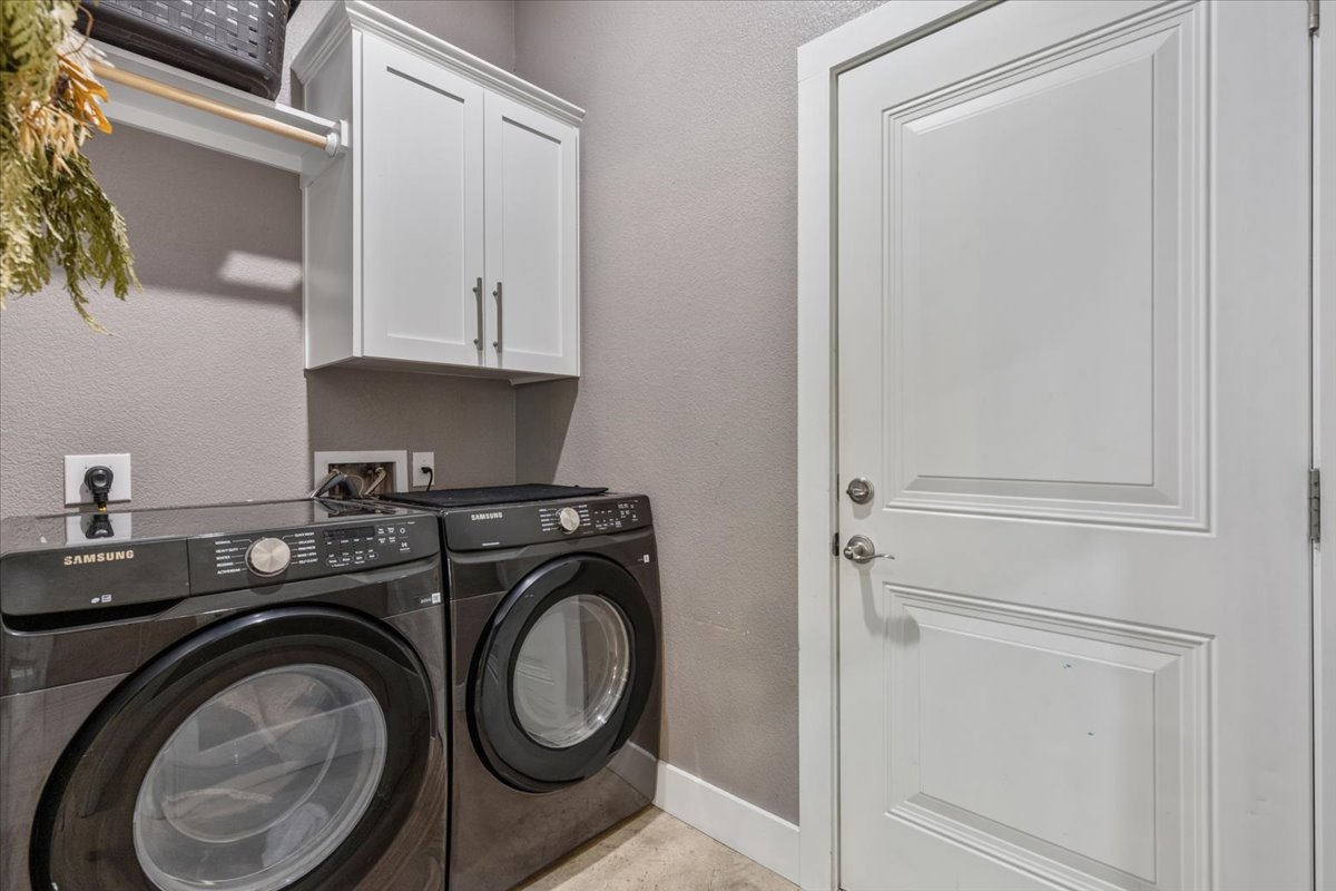 145 Cardinal Loop Paige, TX 78659 - Photo 32 of 40 Functional laundry room featuring a washer, dryer, and cabinetry for storage.