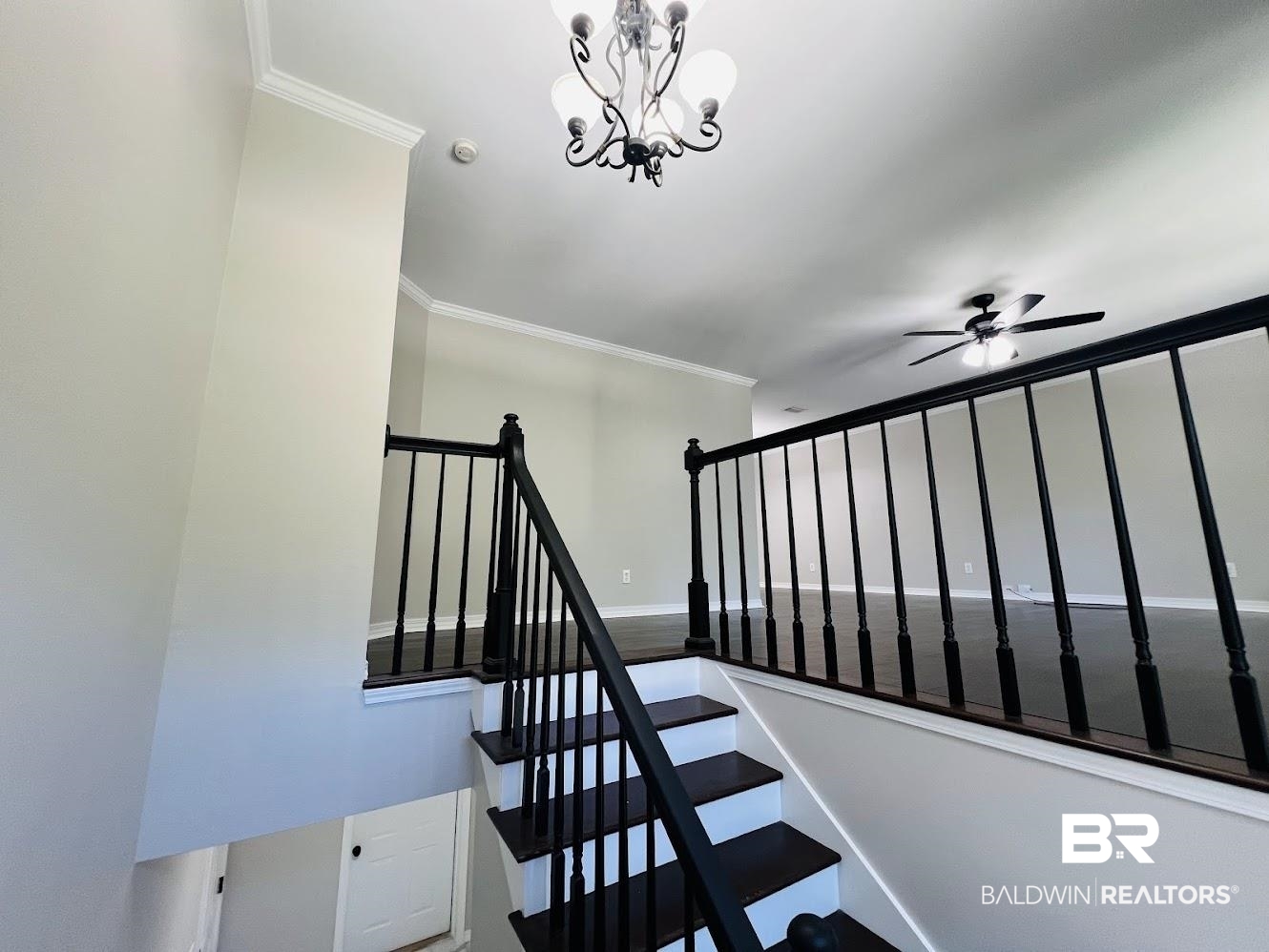 266 Ridgewood Drive Daphne, AL 36526 - Photo 3 of 34 Staircase with dark wood-finish treads and white risers, featuring a black spindle railing