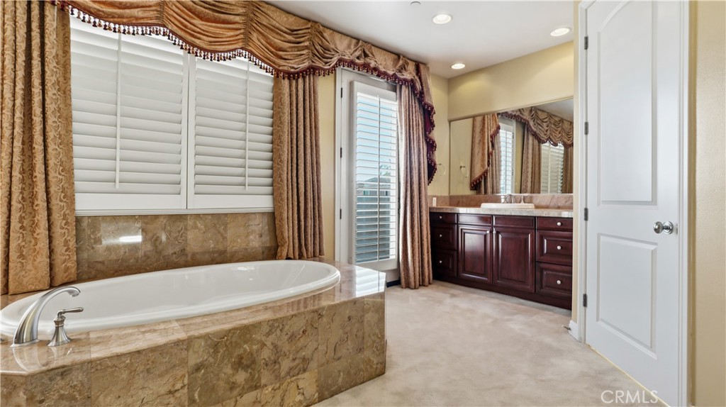 18549 Clydesdale Road Granada Hills, CA 91344 - Photo 40 of 56 a bathroom with a tub a sink and a large mirror
