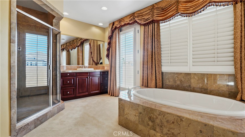 18549 Clydesdale Road Granada Hills, CA 91344 - Photo 41 of 56 a bathroom with a tub a sink and glass door