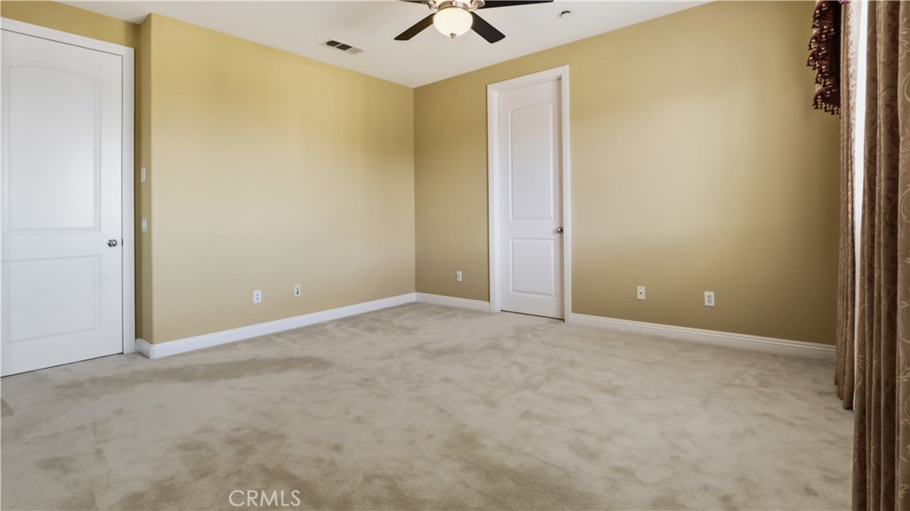 18549 Clydesdale Road Granada Hills, CA 91344 - Photo 44 of 56 an empty room with a ceiling fan and carpet