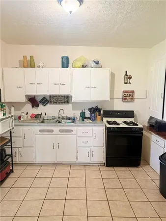 a kitchen with granite countertop a stove top oven cabinetry a sink and a counter top space