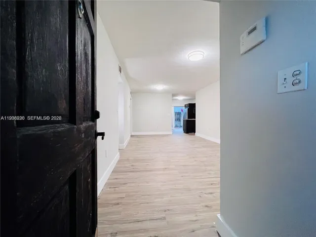a view of a hallway with wooden floor