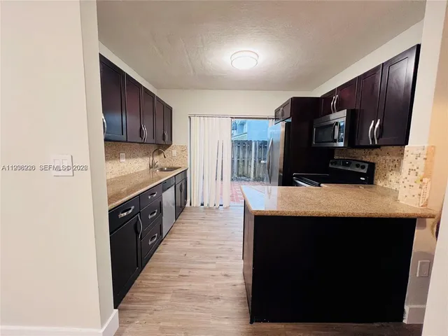 a kitchen with stainless steel appliances granite countertop a stove a sink and a microwave