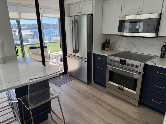 a kitchen with stainless steel appliances a stove a microwave and a hard wood floor