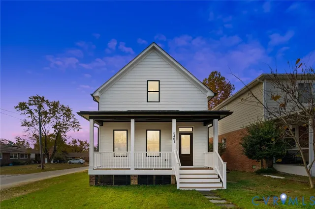 a living room with furniture a clock on wall and a window