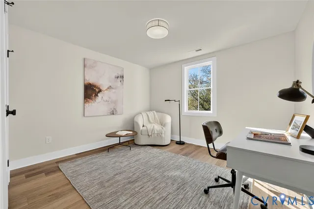 a view of a room with wooden floor and white walls