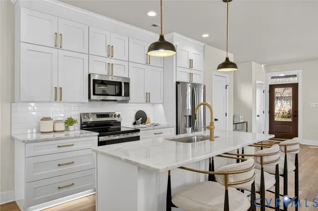 a kitchen with kitchen island granite countertop a sink a counter space appliances and cabinets
