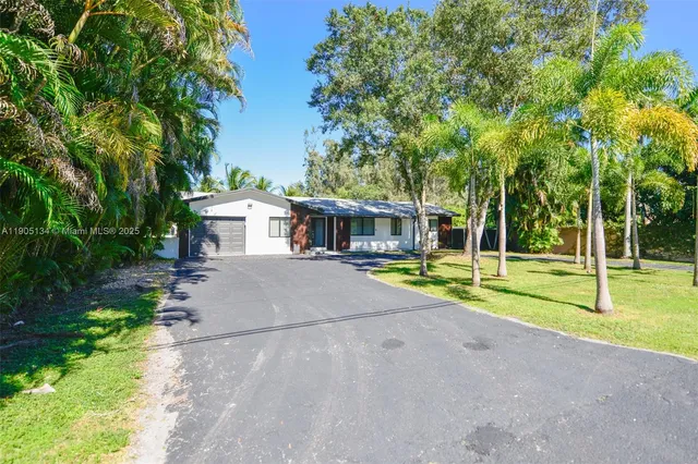 a view of house with swimming pool and yard