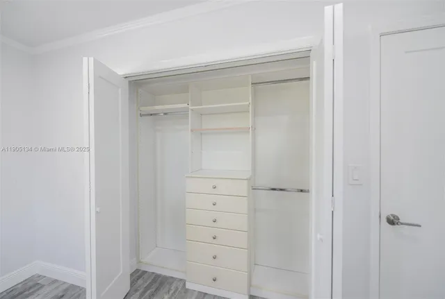 an empty room with wooden floor and window