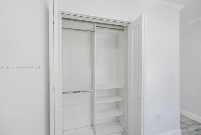 a view of walk in closet with empty racks