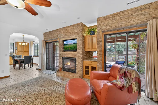 a living room with furniture a fireplace and a floor to ceiling window