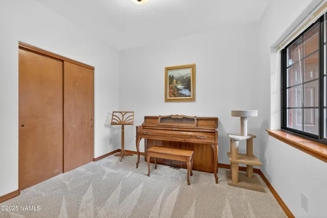a bedroom with a bed and a dresser next to a window