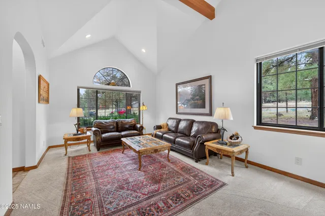 a living room with furniture wooden floor and a large window